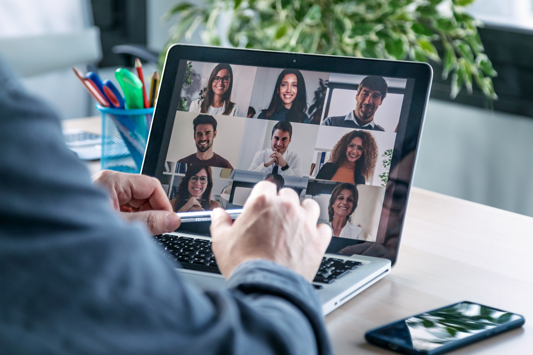 Male employee speaking on video call with diverse colleagues on online briefing with laptop at home.;